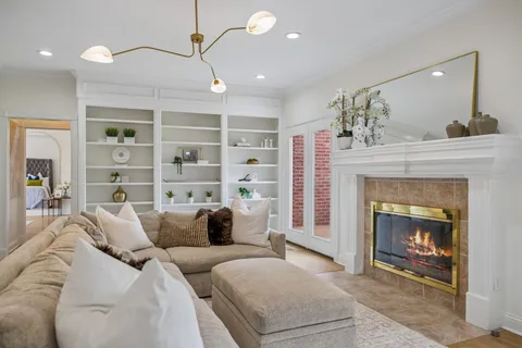 a kitchen with stainless steel appliances granite countertop a stove top oven a refrigerator a sink and white cabinets with wooden floor