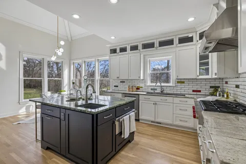 a kitchen with stainless steel appliances granite countertop a sink and a stove