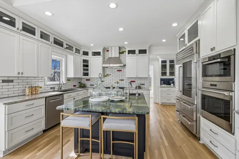 a bathroom with a granite countertop sink and a toilet