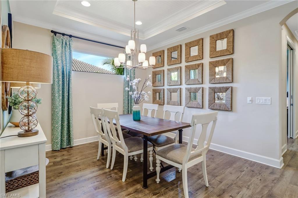 3280 Miyagi Lane Naples, FL 34114 - Photo 12 of 25 a view of a dining room with furniture a chandelier and wooden floor