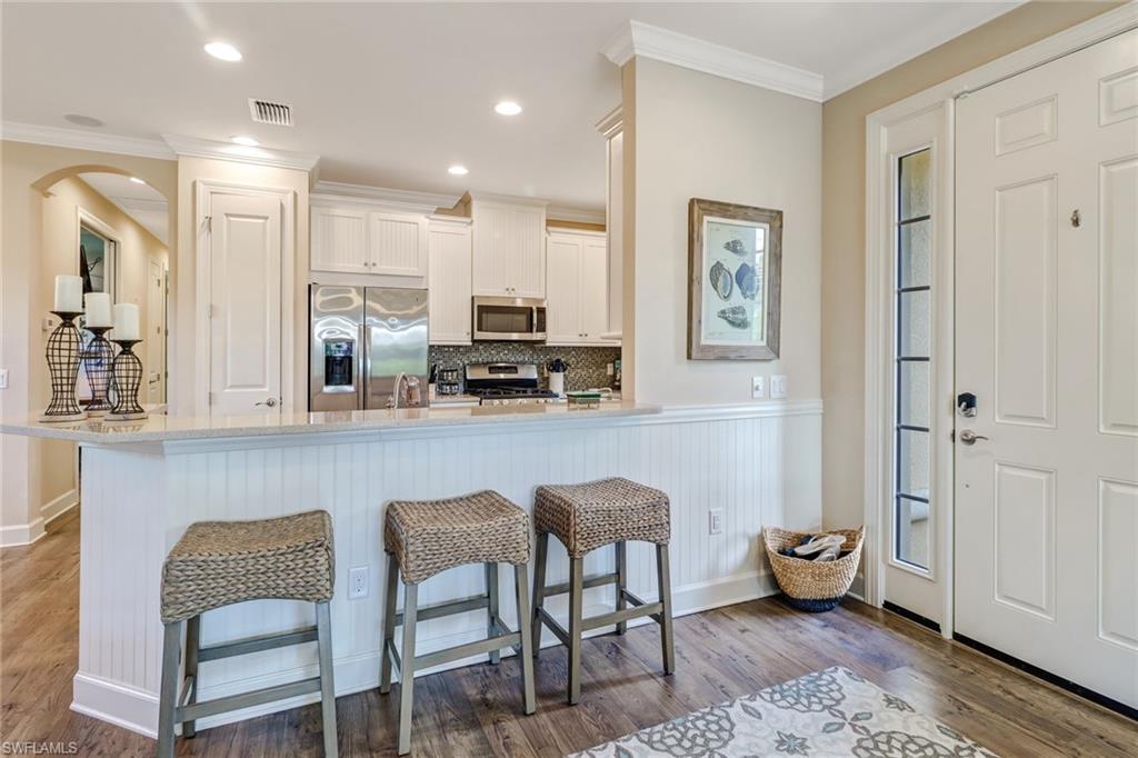 3280 Miyagi Lane Naples, FL 34114 - Photo 4 of 25 a kitchen with stainless steel appliances granite countertop a table and chairs in it