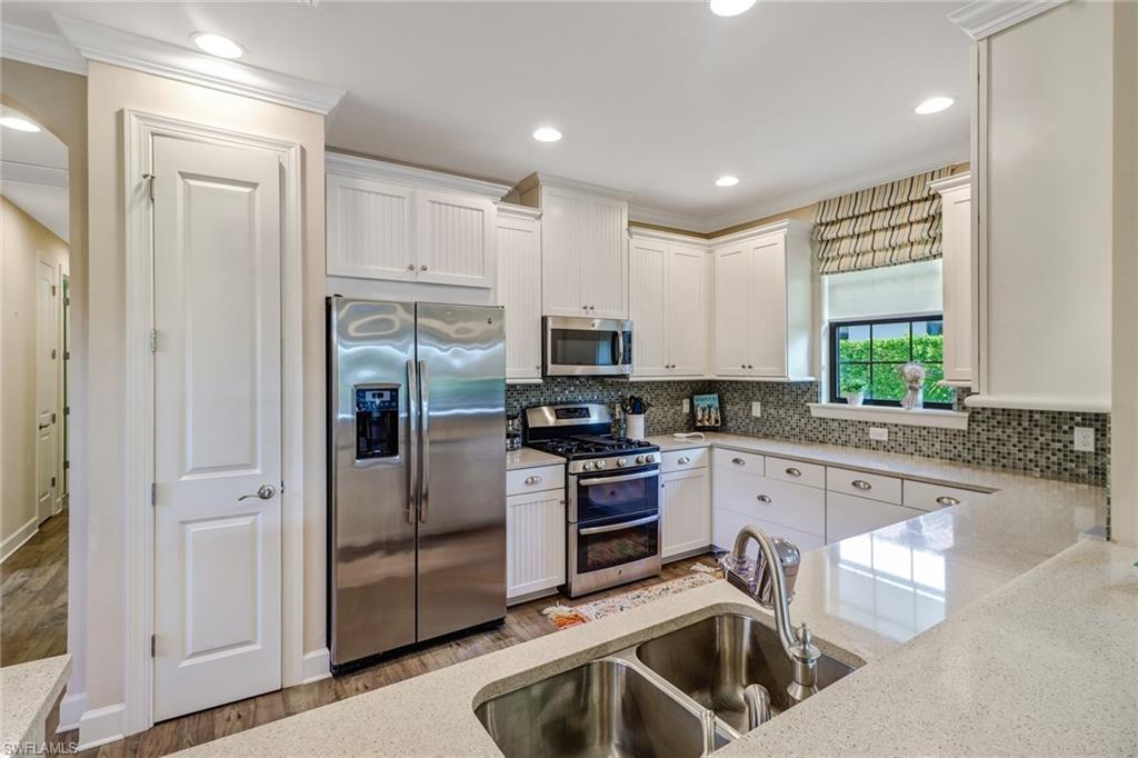 3280 Miyagi Lane Naples, FL 34114 - Photo 7 of 25 a kitchen with granite countertop a sink stainless steel appliances and cabinets