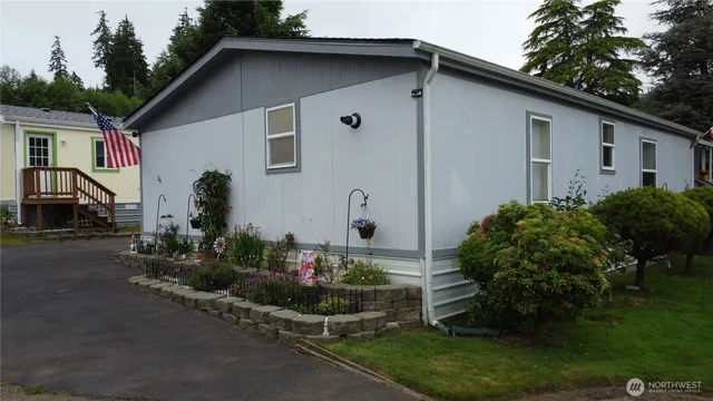 a backyard of a house with potted plants and a large tree