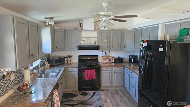 a kitchen with stainless steel appliances granite countertop a refrigerator stove and sink
