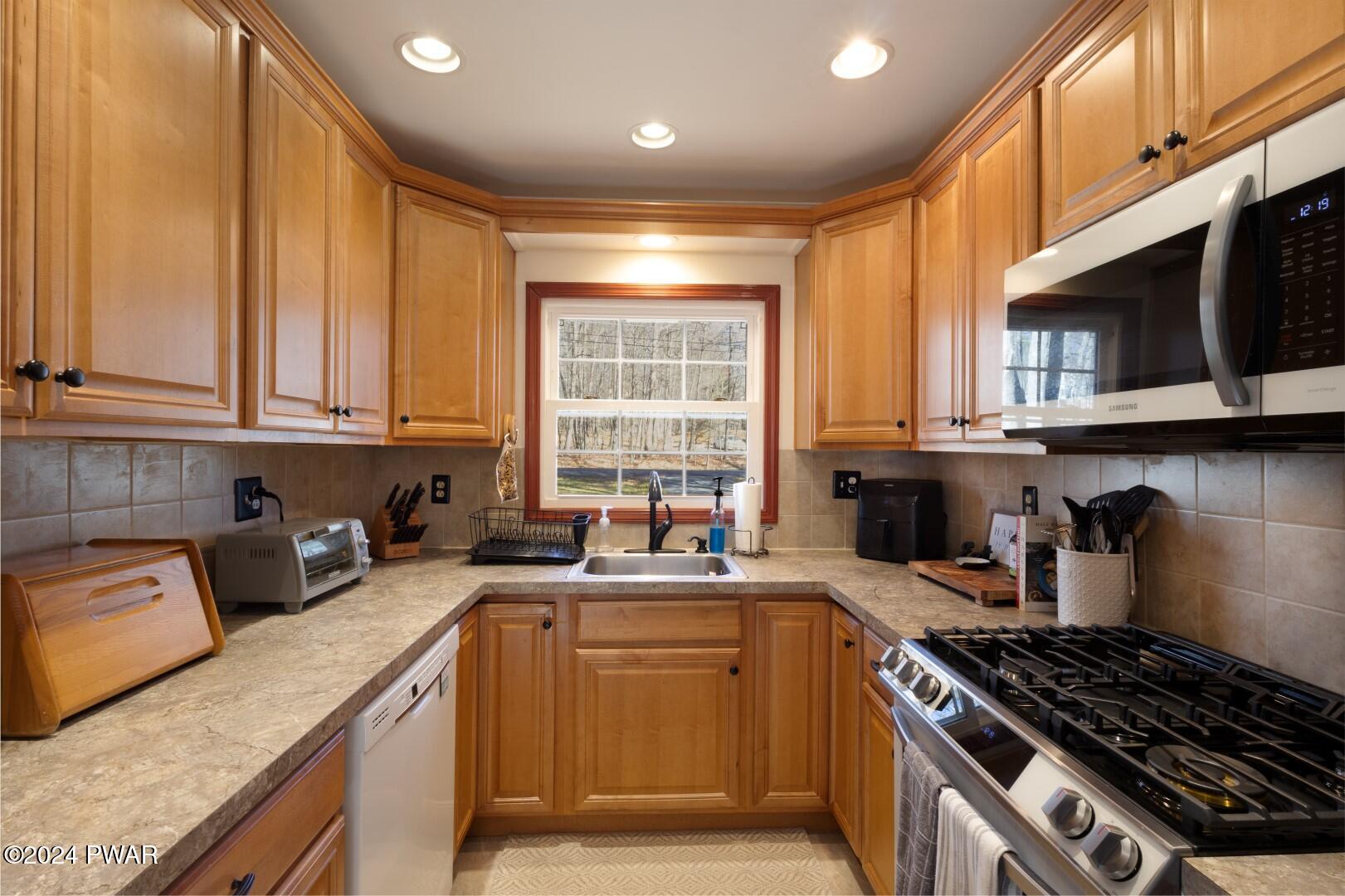 137 Stonehenge Road Milford, PA 18337 - Photo 8 of 30 a kitchen with stainless steel appliances granite countertop a stove a sink dishwasher and a microwave