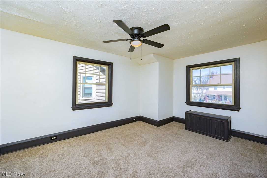 3254 Redwood Road Cleveland Heights, OH 44118 - Photo 37 of 49 Empty room with ceiling fan, a textured ceiling, light carpet, and radiator heating unit