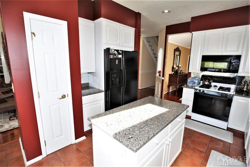 49 Harwood Road Monroe Township, NJ 08831 - Photo 17 of 73 a kitchen with stainless steel appliances kitchen island granite countertop a refrigerator and a stove top oven