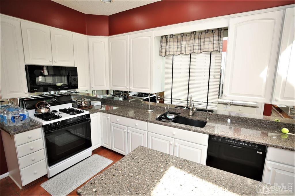 49 Harwood Road Monroe Township, NJ 08831 - Photo 18 of 73 a kitchen with stainless steel appliances granite countertop a sink a stove and a microwave