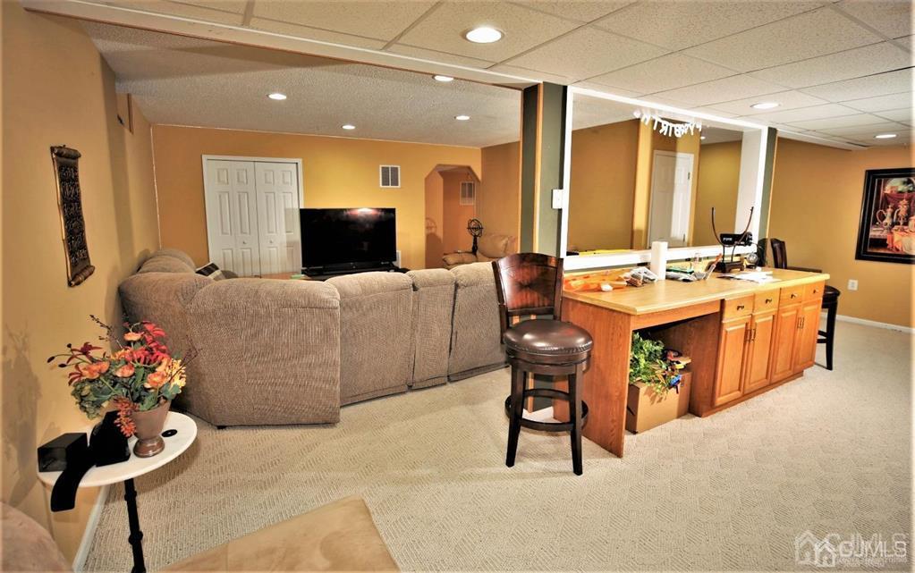 49 Harwood Road Monroe Township, NJ 08831 - Photo 48 of 73 a living room with furniture a chandelier and a fireplace