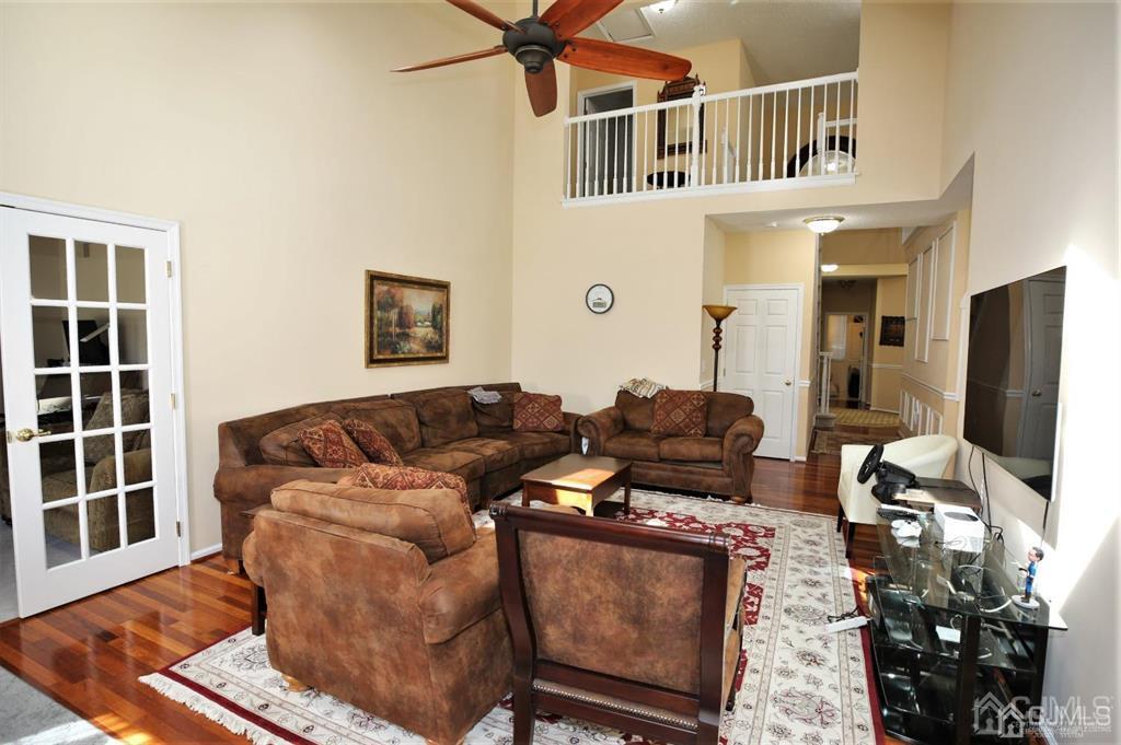 49 Harwood Road Monroe Township, NJ 08831 - Photo 6 of 73 a living room with furniture a flat screen tv and a floor to ceiling window