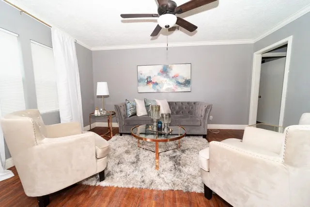 a living room with furniture and a wooden floor
