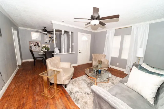 a living room with furniture and wooden floor
