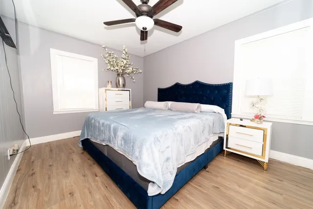 a bed sitting in a bedroom next to a window and a chandelier