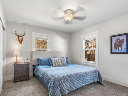 a bedroom with a bed and a painting on the wall