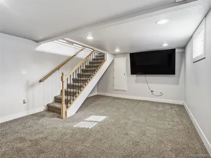 a living room with a flat screen tv and white walls
