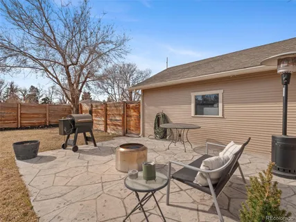 a view of a patio with a dining table and chairs with wooden fence