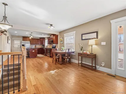 a living room with furniture and a dining table with wooden floor
