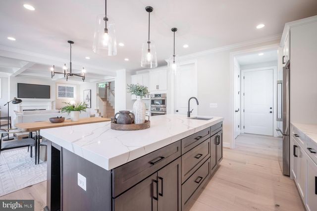 a kitchen with kitchen island a counter space a sink appliances and cabinets