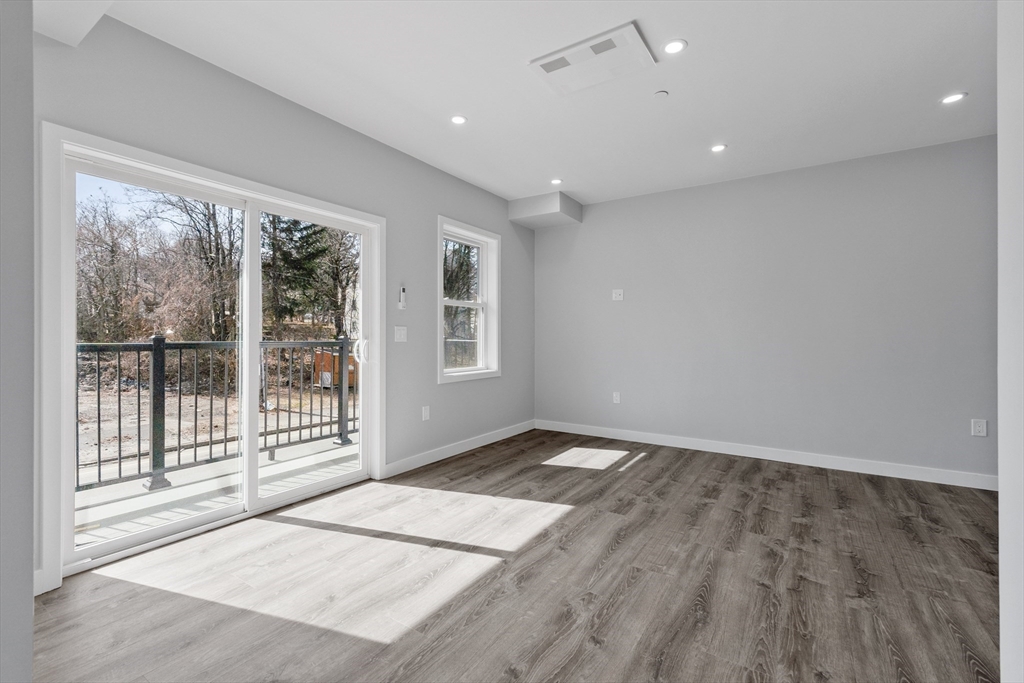 631 Franklin Street, Unit 209 Worcester, MA 01604 - Photo 11 of 42 an empty room with wooden floor and windows