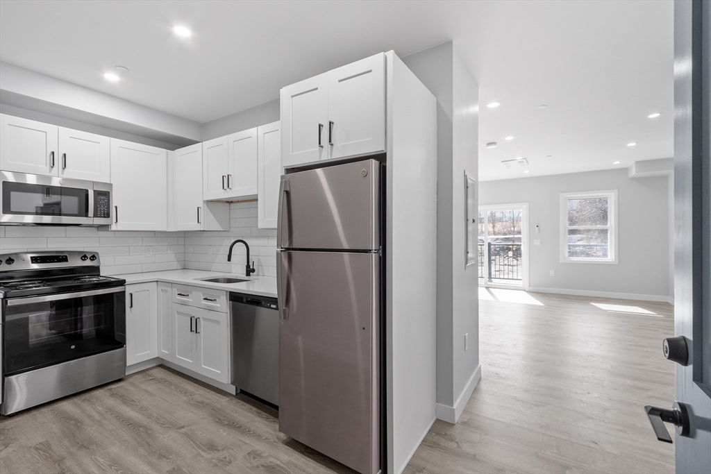631 Franklin Street, Unit 209 Worcester, MA 01604 - Photo 3 of 42 a kitchen with stainless steel appliances a refrigerator sink and microwave