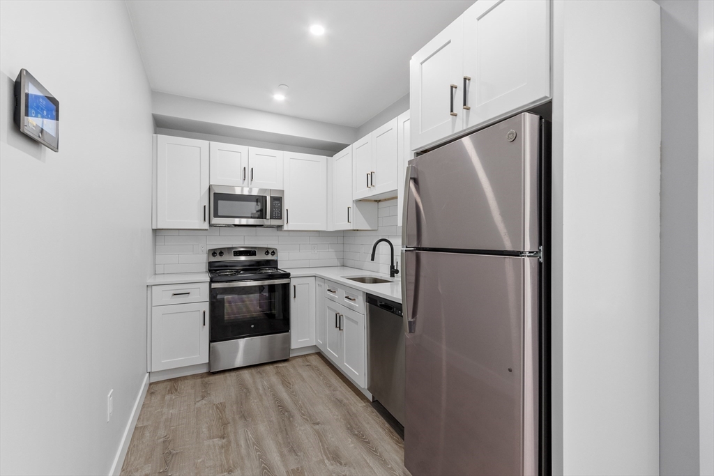 631 Franklin Street, Unit 209 Worcester, MA 01604 - Photo 5 of 42 a kitchen with cabinets stainless steel appliances and a refrigerator