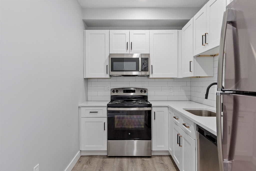 631 Franklin Street, Unit 209 Worcester, MA 01604 - Photo 6 of 42 a kitchen with a stove and a microwave