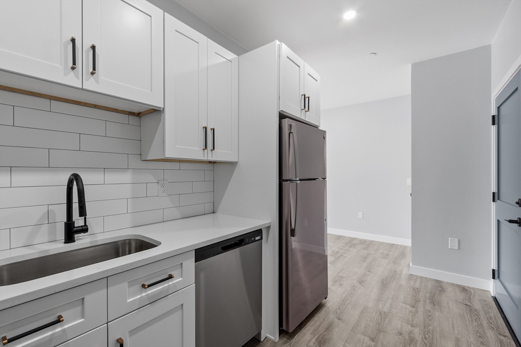 631 Franklin Street, Unit 209 Worcester, MA 01604 - Photo 7 of 42 a kitchen with a sink a refrigerator and cabinets