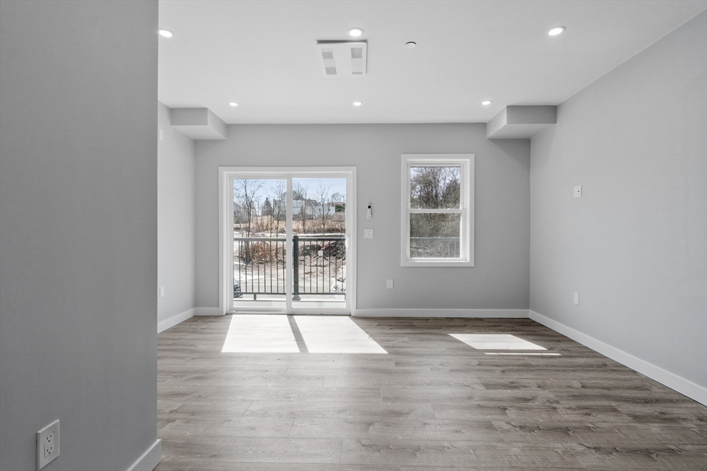 631 Franklin Street, Unit 209 Worcester, MA 01604 - Photo 10 of 42 an empty room with wooden floor and windows