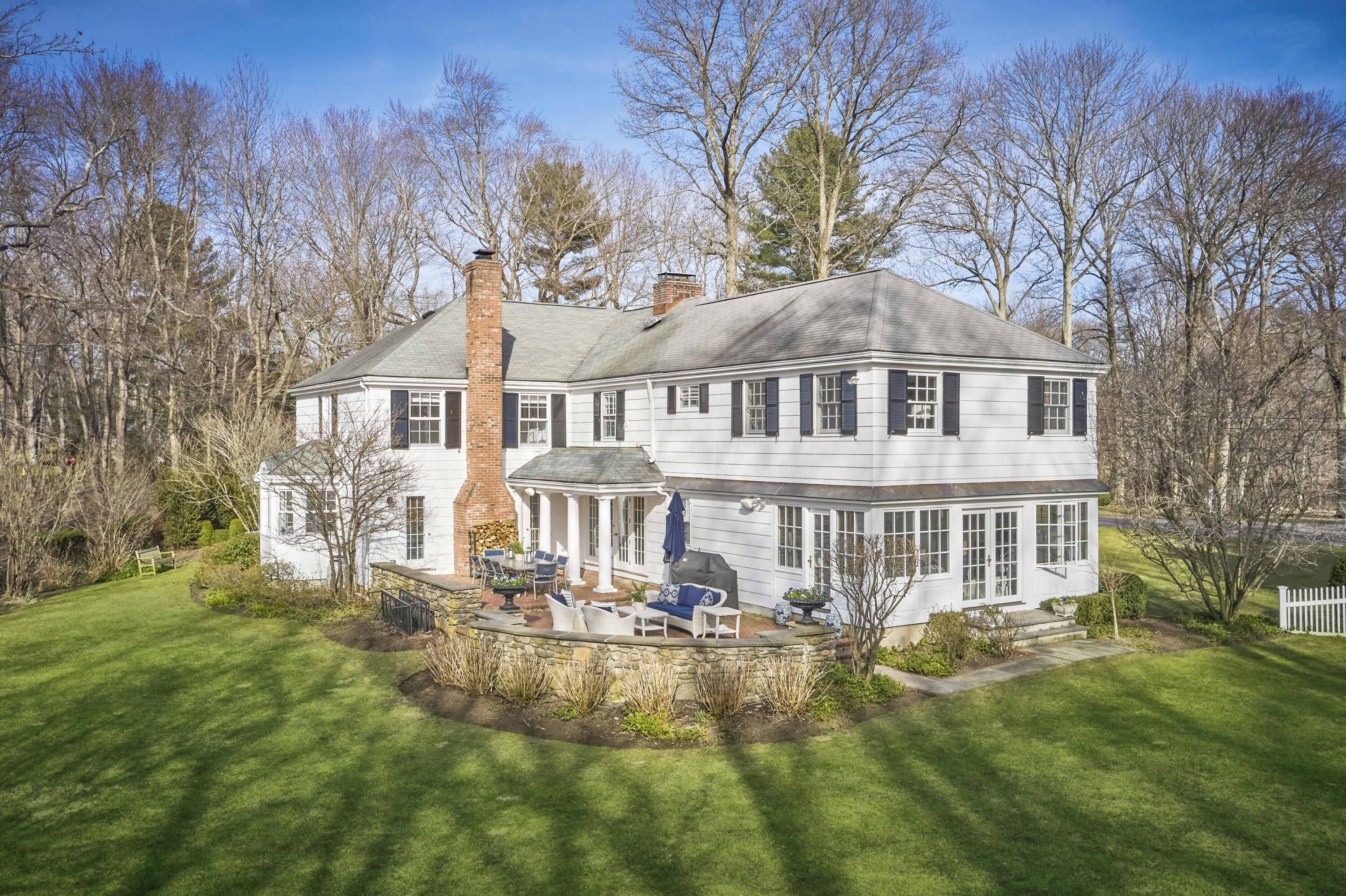 5 Driftway Lane Darien, CT 06820 - Photo 42 of 46 a front view of a house with a yard table and chairs