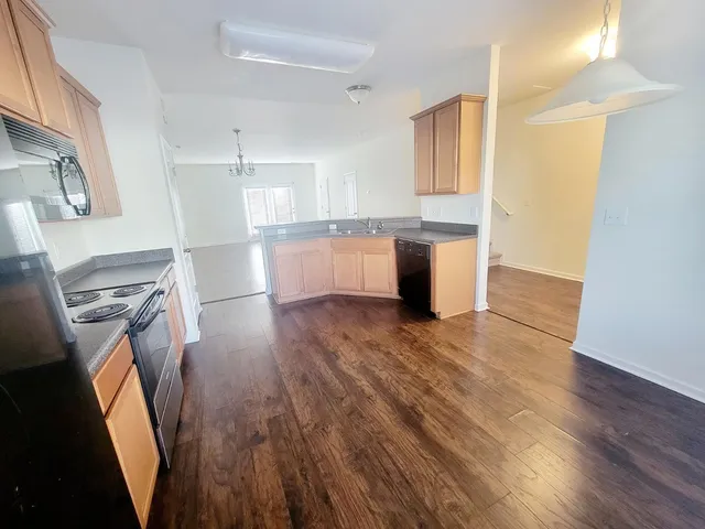 a view of a kitchen with wooden floor and electronic appliances