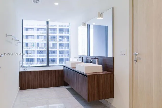 a bathroom with a double vanity sink and a mirror