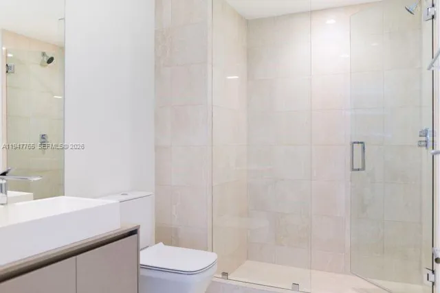 a bathroom with a sink a toilet a shower and a mirror