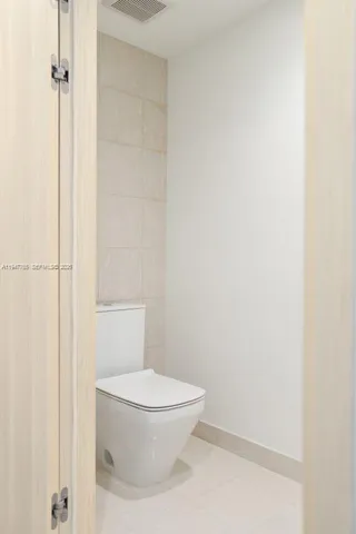 a white toilet sitting next to a shower