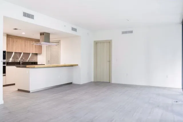 a view of kitchen with kitchen island white cabinets and refrigerator