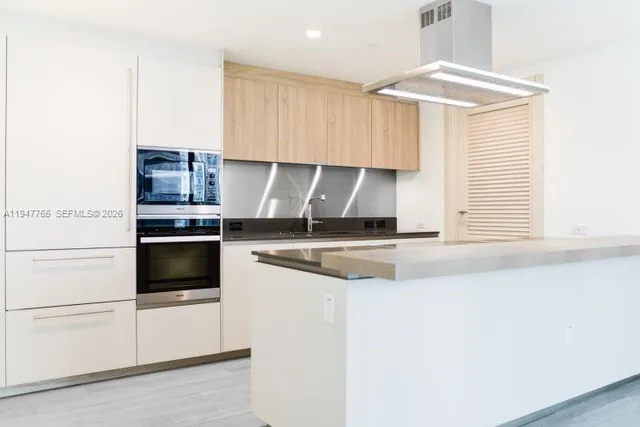 a kitchen with kitchen island a stove a sink and a refrigerator