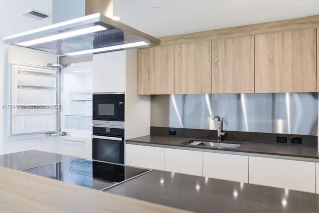 a kitchen with stainless steel appliances granite countertop a sink and a stove