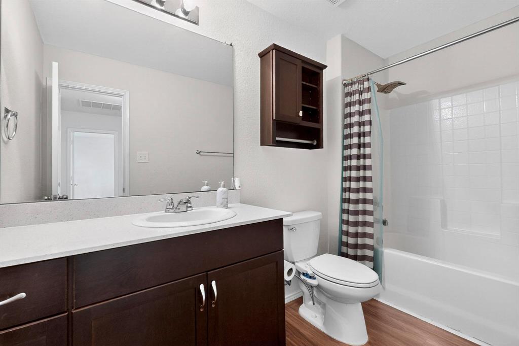 5516 McClelland Street Forney, TX 75126 - Photo 21 of 36 Full bath featuring shower / tub combo with curtain, vanity, and dark wood finished floors
