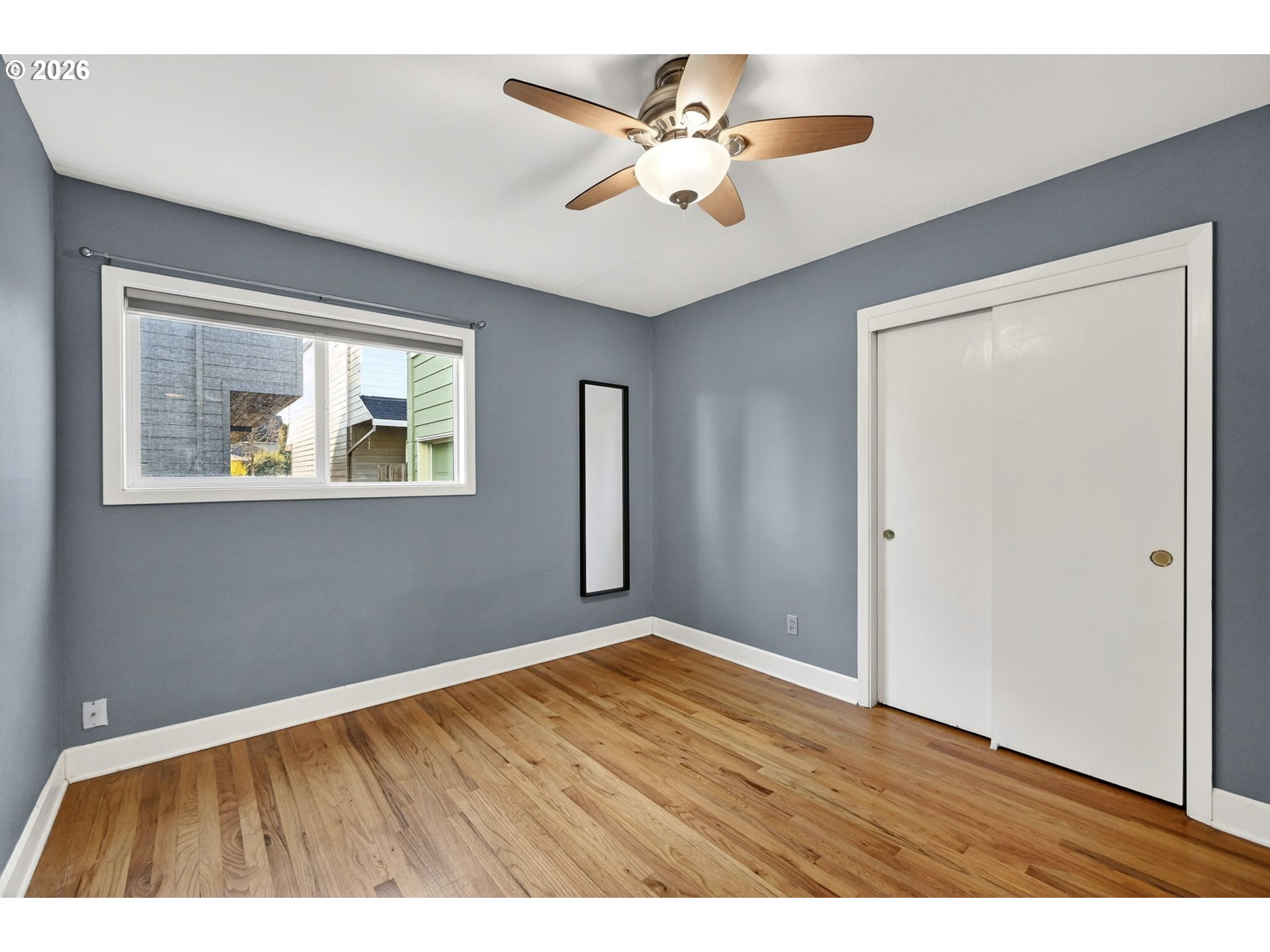5617 Southeast 60th Avenue Portland, OR 97206 - Photo 23 of 34 a view of an empty room with window and wooden floor