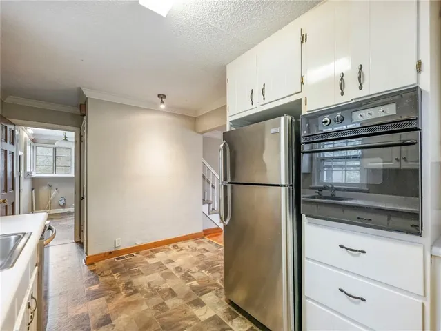 a kitchen with a refrigerator and a stove top oven