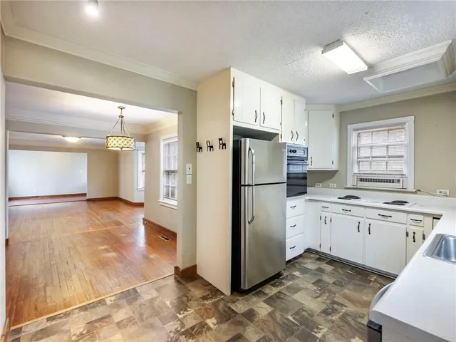 a kitchen with a refrigerator a sink and cabinets