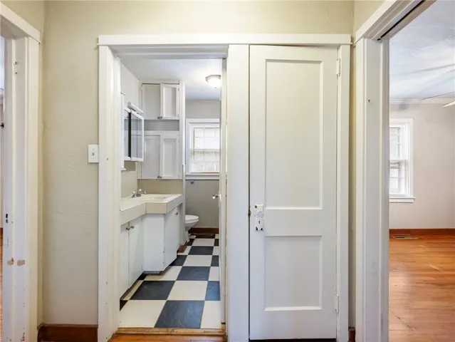 a view of an empty room with window and wooden floor