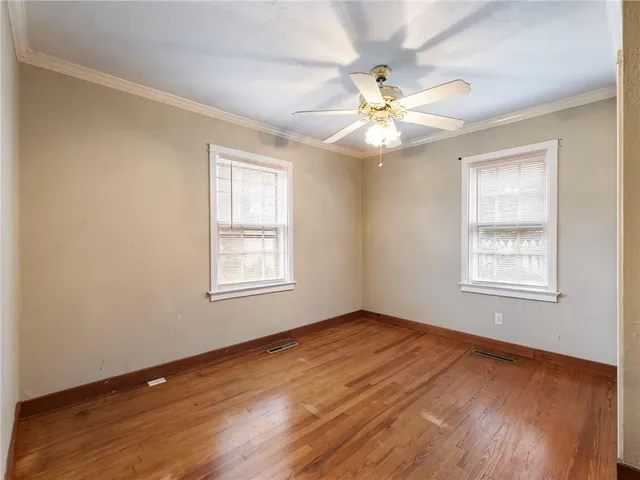 an empty room with fan and a chandelier fan