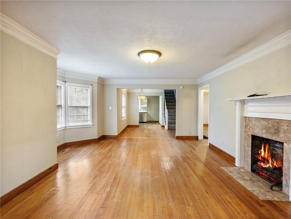 1093 Enota Avenue Northeast Gainesville, GA 30501 - Photo 4 of 47 a view of an empty room with wooden floor fireplace and a window