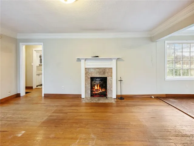 a view of an empty room with a fireplace and a window