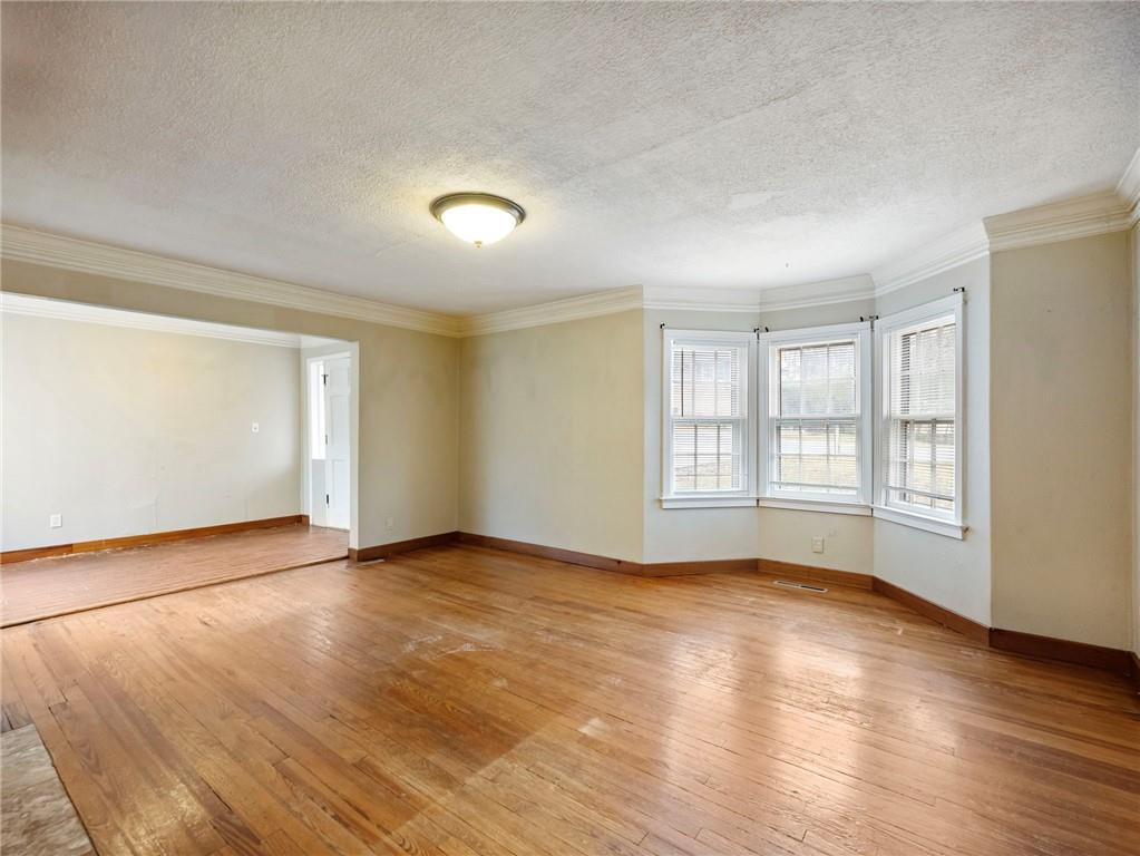 1093 Enota Avenue Northeast Gainesville, GA 30501 - Photo 7 of 47 an empty room with wooden floor and windows