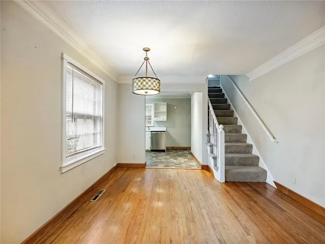 a view of staircase with wooden floor and white walls