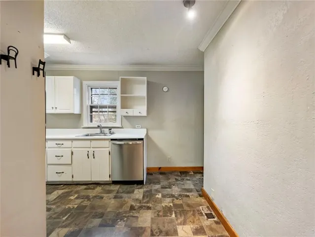 a room with a stove a sink and a window