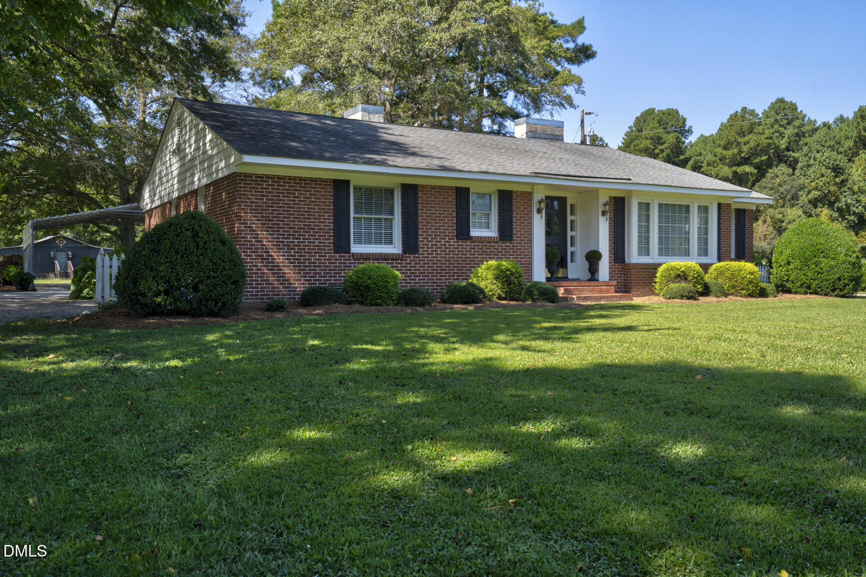 a view of a house with a yard and potted plants