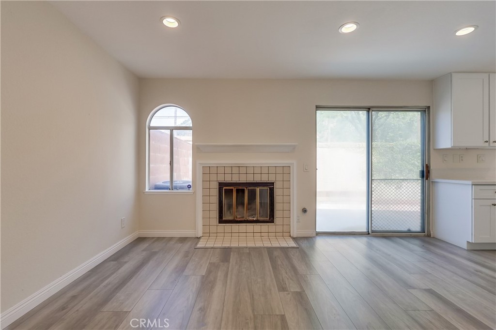 1876 Forest Drive Azusa, CA 91702 - Photo 6 of 24 an empty room with wooden floor fireplace and windows