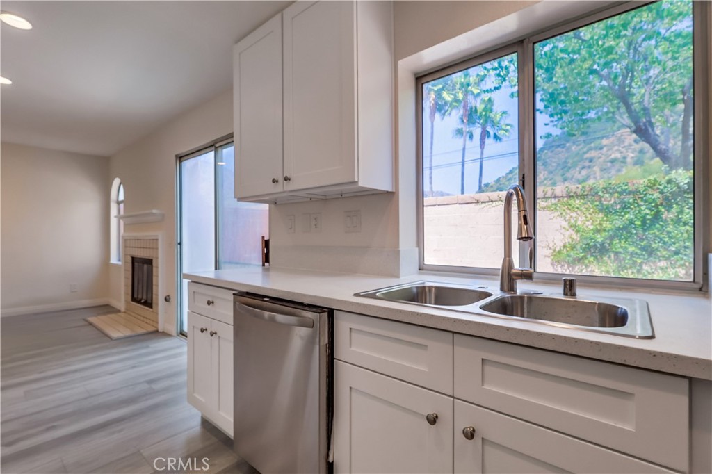 1876 Forest Drive Azusa, CA 91702 - Photo 9 of 24 a kitchen with stainless steel appliances white cabinets a sink and a large window